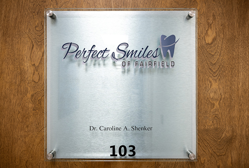 A professional dental office sign with the name Perfect Smiles and a logo, indicating a dental practice.